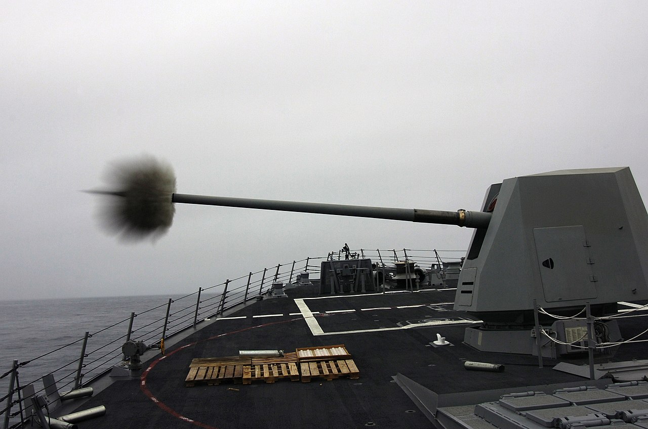 1280px-Mk_45_gun_of_USS_Preble_(DDG-88)_firing_during_pre-aim_calibration_fire_US_Navy_050819-...jpg
